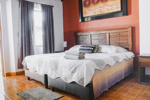 a bedroom with a large bed with orange walls at La Ventana del Tepozteco in Tepoztlán