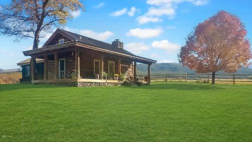 a small house on a green field with a fence at Timeless Mesa Hideaway cabin in Mesa