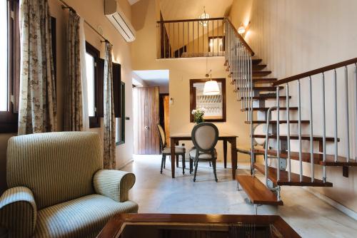 a living room filled with furniture and a staircase at Singular Corral de San José in Seville