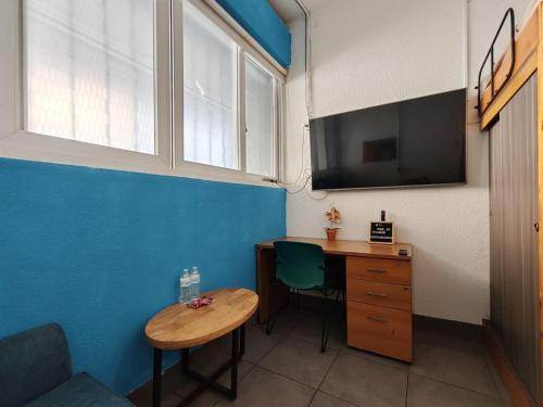 a room with a desk and a tv and a table at Apartamento zona 1 in Guatemala