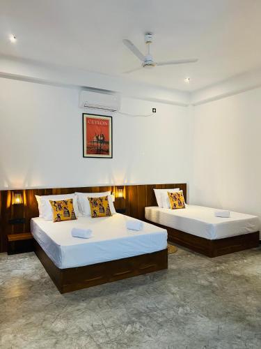 a bedroom with two beds in a room at Sunset Bay in Dickwella