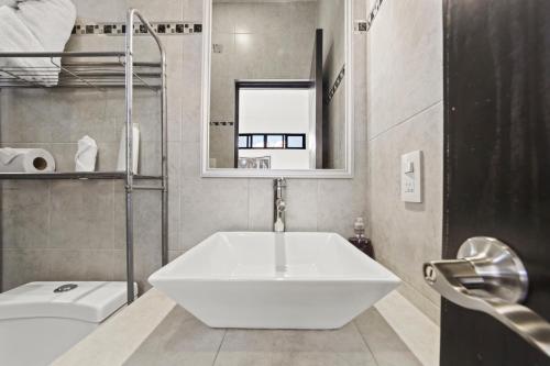 a bathroom with a large white tub and a sink at Hotel Boutique Árbol de la Vida in Taxco de Alarcón