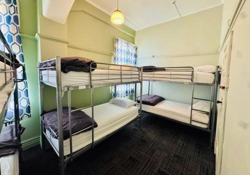 a room with three bunk beds in it at Crashpalace Napier in Napier
