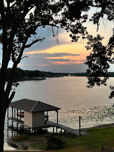 a dock with a shelter on the water at sunset at Retreat on Lake Athens in Athens