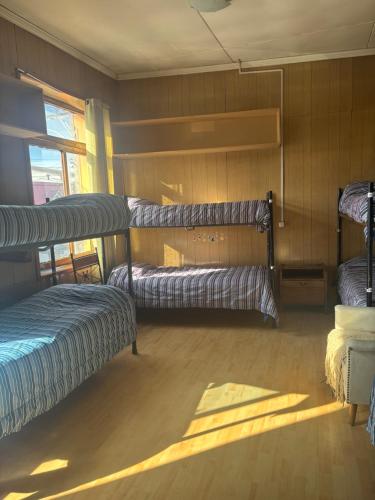 una habitación con tres literas y una ventana en Hostel La Morenita, en Punta Arenas