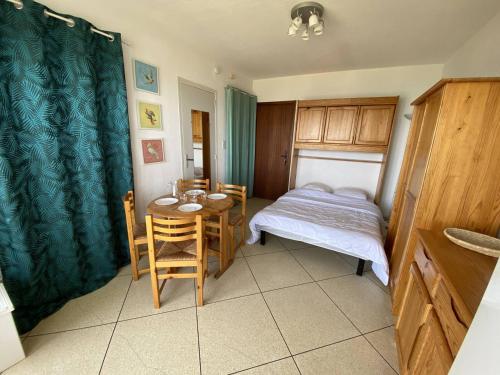 - une petite chambre avec un lit, une table et des chaises dans l'établissement Appartement au Lavandou avec terrasse vue mer et parking - FR-1-816-17, au Lavandou