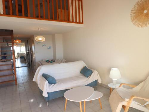 une chambre avec un lit, une table et des chaises dans l'établissement Duplex 2 pièces avec terrasse, clim, tennis et WIFI - FR-1-472A-311, à Sète