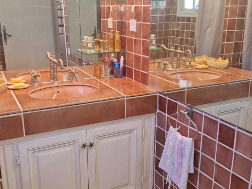 une salle de bain avec deux lavabos et un grand miroir dans l'établissement Maison climatisée avec grand jardin, proche plage et commerces - FR-1-610-102, à Bormes-les-Mimosas