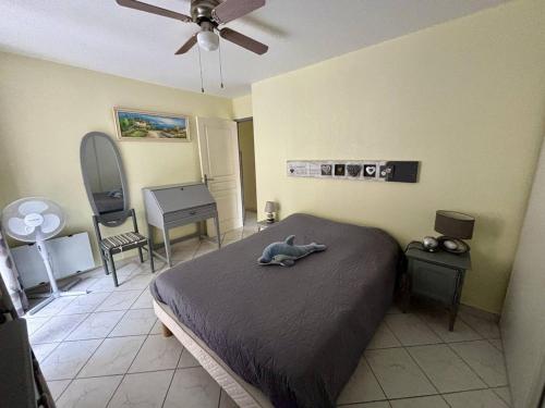 une chambre avec un lit et un ventilateur de plafond dans l'établissement Appartement climatisé avec garage à 200m des commerces - FR-1-816-19, à Bormes-les-Mimosas