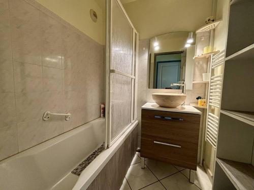 une salle de bain avec un lavabo et une baignoire et un lavabo dans l'établissement Appartement climatisé avec garage à 200m des commerces - FR-1-816-19, à Bormes-les-Mimosas
