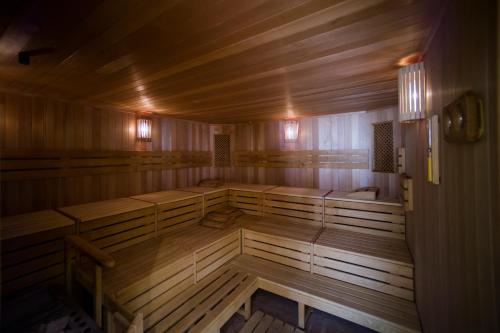 an empty sauna with wooden tables and benches at Szidónia Castle in Röjtökmuzsaj