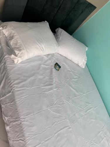 a white bed with white sheets and pillows at Flats &Residences - Studio Moderno e Completo in Passo Fundo