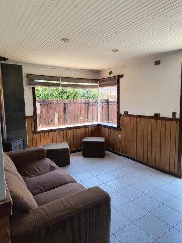 a living room with a couch and a large window at Arriendo Vacaciones Futrono in Futrono