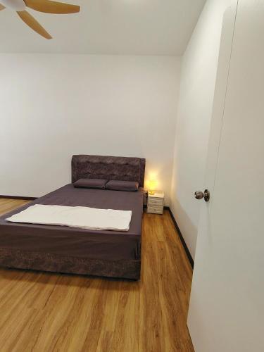 a bedroom with a bed and a white wall at D Banyan Homestay, Bukit Banyan in Sungai Petani