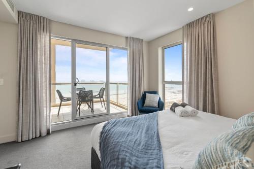 a bedroom with a bed and a view of the ocean at Belle Escapes - Ocean Views at the Bay in Glenelg