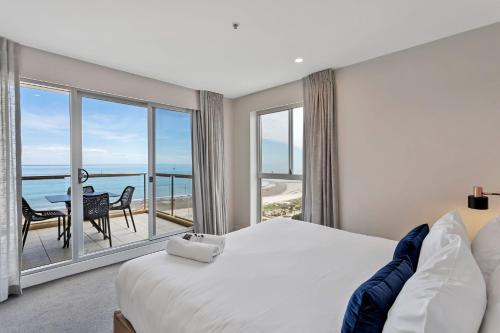 a bedroom with a bed and a view of the ocean at Belle Escapes - Ocean Views at the Bay in Glenelg