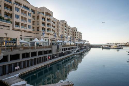 a large apartment building next to a body of water at Belle Escapes - Ocean Views at the Bay in Glenelg