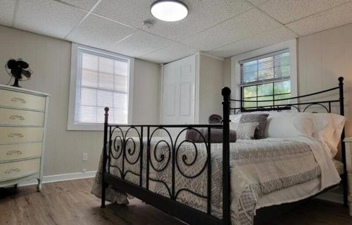 a bedroom with a black bed and two windows at Relaxed Lake Front Cottage 2 Bedrooms Sleeps 6 Pet Friendly in Keystone Heights