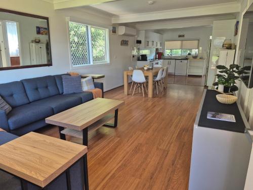 a living room with a couch and a table at Cottage on Clare in Batehaven