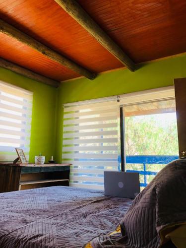 a bedroom with a bed with a laptop on it at Casa Mamalluca in Vicuña