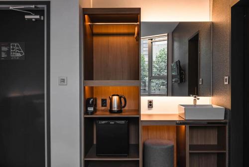 a small kitchen with a sink and a microwave at Pillowsopher Hongdae in Seoul