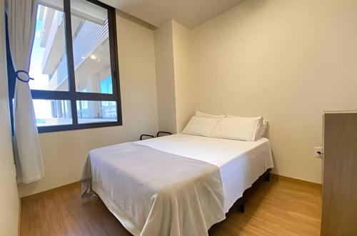 a bedroom with a white bed and a window at Central, Ar Cond, WI-FI, Lava e Seca in Santa Maria