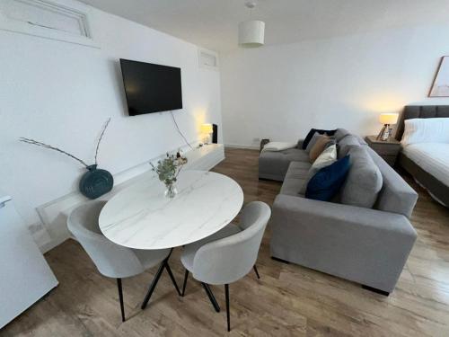 a living room with a white table and a couch at Modern studio in popular South Kensington location in London