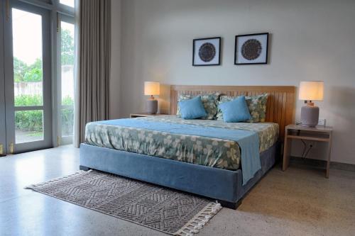 a bedroom with a large bed with blue pillows at TRES Galle in Galle
