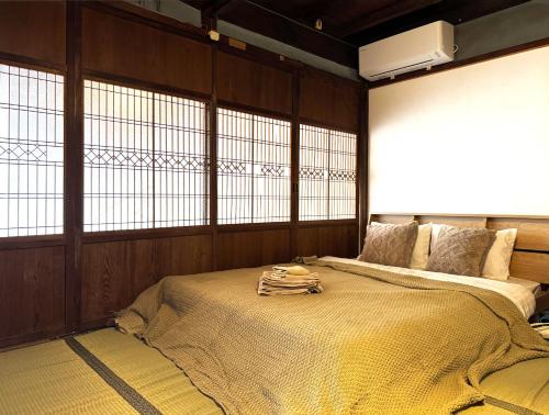a bedroom with a large bed in a room with windows at 焼津 梔子 古民家の宿-カモメの鳴き声が聴こえる港町 in Yaizu