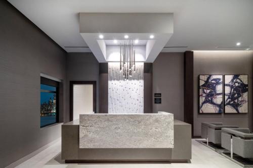 a lobby with a marble counter and a chandelier at Residence Inn by Marriott Weehawken in Weehawken