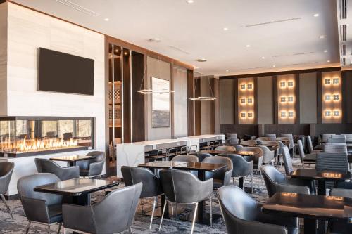 a restaurant with tables and chairs and a flat screen tv at Residence Inn by Marriott Weehawken in Weehawken