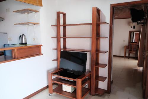 uma sala de estar com televisão numa prateleira em Arbiru Beach Resort em Dili