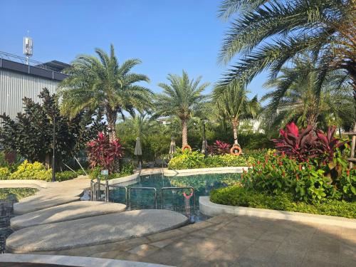 a swimming pool with palm trees in a resort at ZoZo House - Homestay Bai Sau - bien Vung Tau in Vung Tau