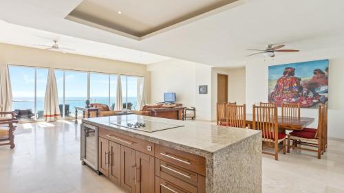 eine Küche und ein Esszimmer mit Blick auf das Meer in der Unterkunft Encanto Living Penthouse 1202 by Kivoya in Playa Encanto