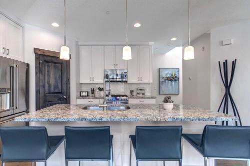 a kitchen with a large island with blue chairs at Retreat at Jordanelle 1157 in Kamas