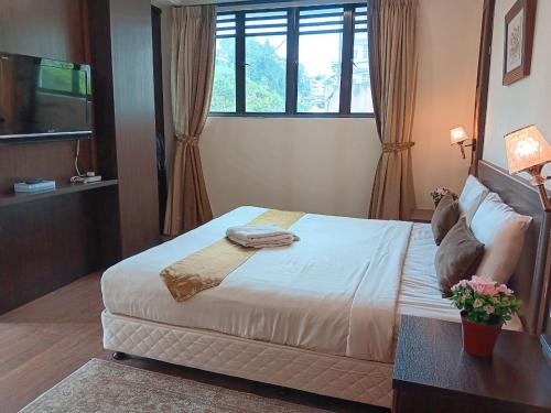 a bedroom with a large bed and a window at Melur Inn in Cameron Highlands