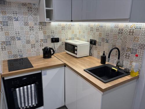 Apartament centrum في بياويستوك: طاولة مطبخ مع ميكروويف ومغسلة