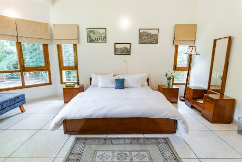 a bedroom with a large bed and some windows at SaffronStays Doon Garden Villa - near Doon School and Mall Road in Dehradun