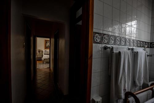 a bathroom with white towels hanging on a wall at Kleine Constantia Boutique Guest House in Roodepoort