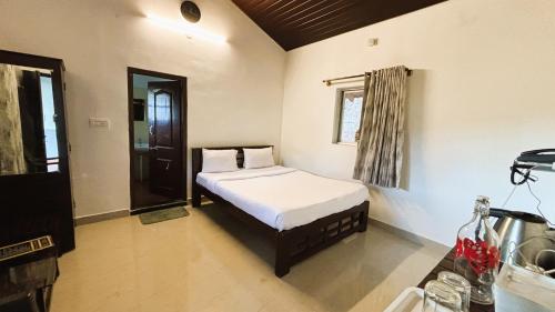 a bedroom with a bed in the corner of a room at Hong Sau Resort in Sakleshpur
