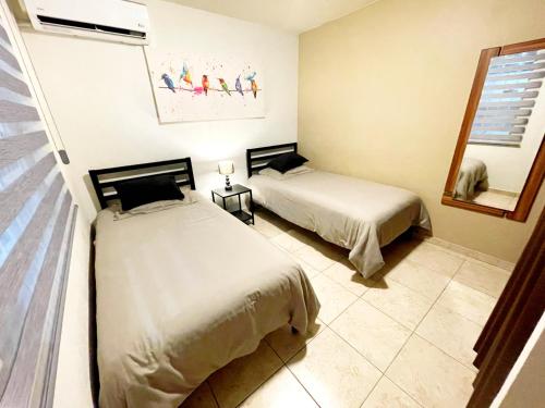 a bedroom with two beds and a mirror at Casa Málaga in Zamora de Hidalgo