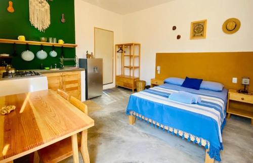 a bedroom with a large bed and a kitchen at Palmar la Punta 10 AC Starlink 2min walk to beach in Brisas de Zicatela