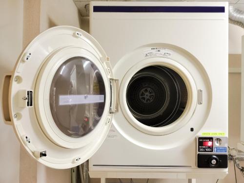 a large white washing machine sitting next to a washingmachine at Tabist Business Hotel Suehiro Matsuyama in Matsuyama