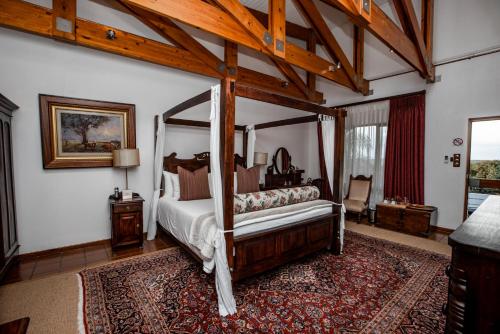 a bedroom with a canopy bed and a rug at Kleine Constantia Boutique Guest House in Roodepoort