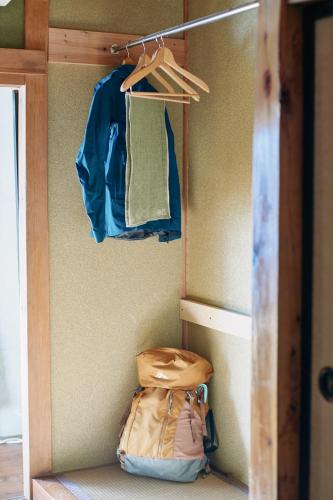 a room with a closet with a bag and a jacket at ふもとの山小屋 ネイバーズ Neighbors - Alpine Base Inn in Matsumoto