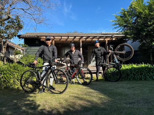 three men standing with their bikes in front of a house at 紀州安兵衛 in Kushimoto