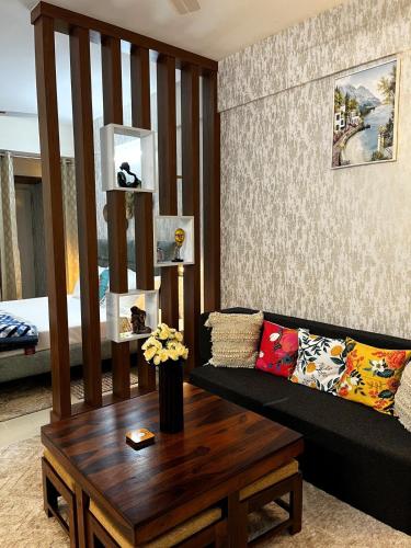 a living room with a couch and a table at Solan Woods - Cozy Studio Apartment in Chester Hills, Solan in Solan