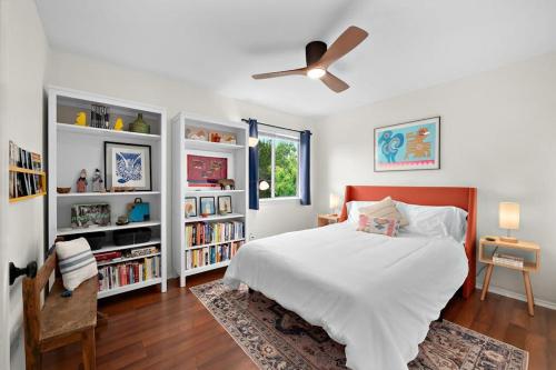 Un dormitorio con una cama y un ventilador de techo. en Artist Retreat on the Creek - Sleeps 10 - Hot tub, en Leander