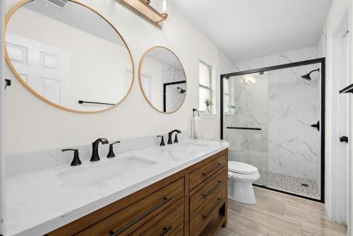 Un baño con lavabo, ducha y espejo. en Artist Retreat on the Creek - Sleeps 10 - Hot tub, en Leander