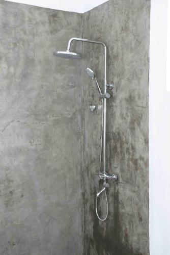 a shower with a shower head on a wall at Indunil place hiriketiya in Dickwella